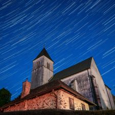 A low-angle shot of a church at the summit of Magdalensberg in Carinthia, under the sky full of stars